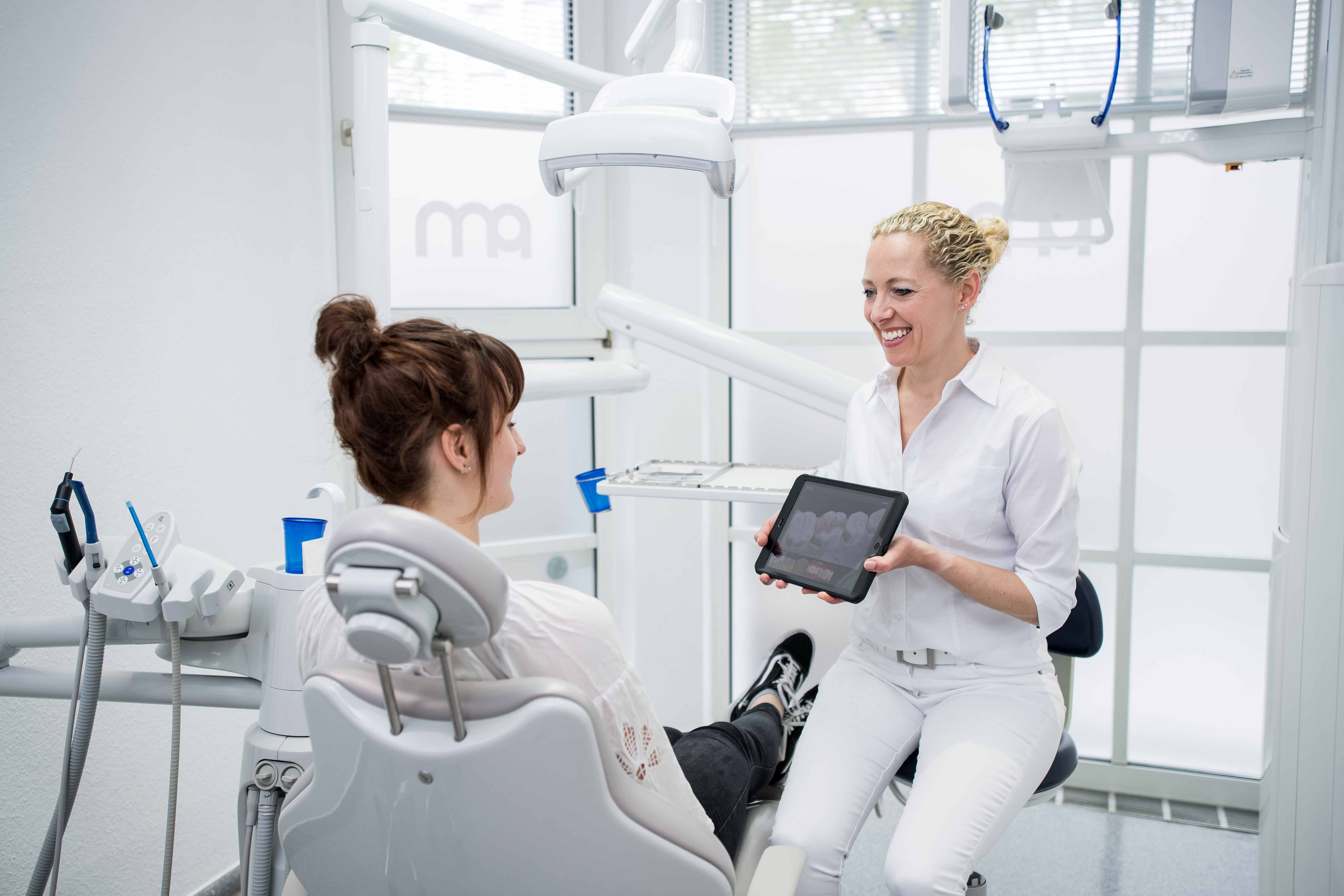 Frau Dr. Münker zeigt einer Patientin das Behandlungsergebnis auf einem iPad