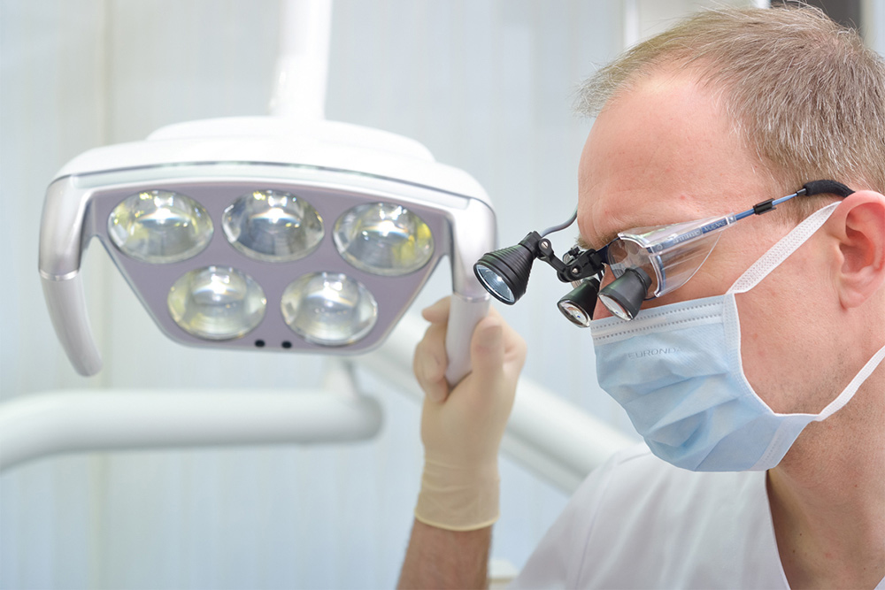 Dr. Münker untersucht die Zähne eines Patienten