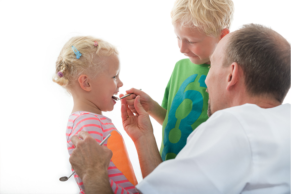 Dr. Münker und 2 Kinderpatienten in der Praxis