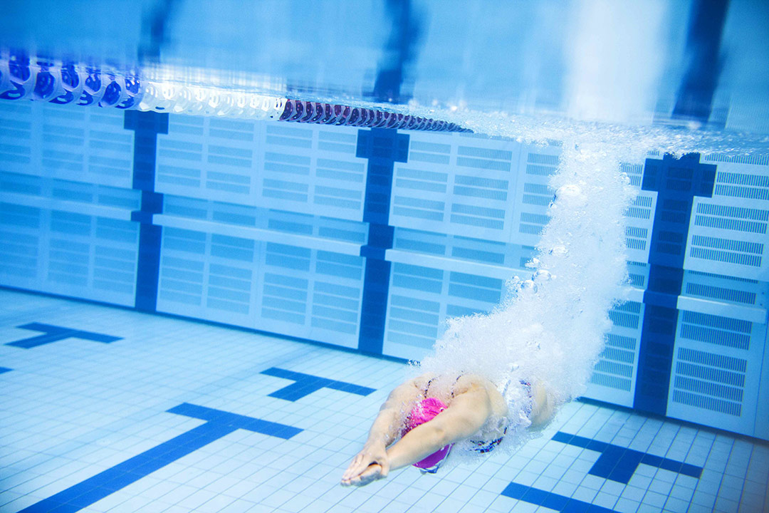 Eine Patientin macht einen Kopfsprung ins Schwimmbecken